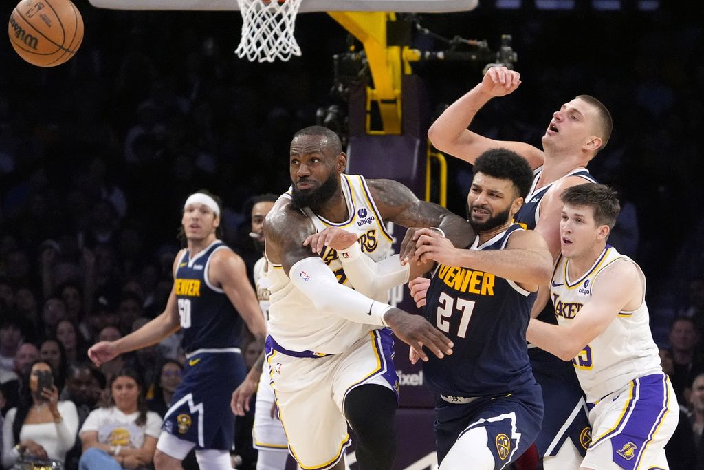 Pebasket Los Angeles Lakers, LeBron James, coba meloloskan diri dari kepungan pebasket Denver Nuggets dalam pertandingan keempat babak pertama <i>playoff</i> Wilayah Barat antara Lakers dan Denver Nuggets di Los Angeles, Minggu (28/4/2024) pagi WIB. Lakers menang 119-108 dalam laga tersebut.