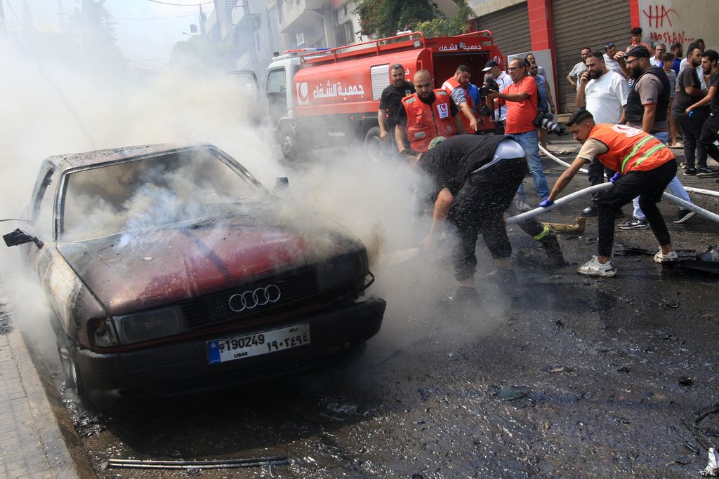 Petugas pemadam kebakaran Lebanon memadamkan api di sebuah mobil setelah serangan Israel di kota selatan Sidon, Lebanon, Rabu (21/8/2024). Serangan itu menewaskan seorang komandan Fatah, Khalil Maqdah. 