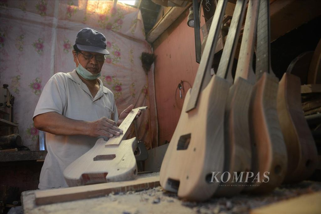 Ilustrasi. Pekerja menghaluskan permukaan gitar elektrik yang dibuat dari kayu mahoni dan <i>maple</i> di industri kreatif Zakk Zakk Guitar, Kelurahan Patehan, Kecamatan Kraton, Yogyakarta, Kamis (8/8/2019). Gitar dengan sasaran konsumen anak-anak serta gitaris yang suka bepergian tersebut dipasarkan dengan harga berkisar Rp 900.000-Rp 1,8 juta per buah. 