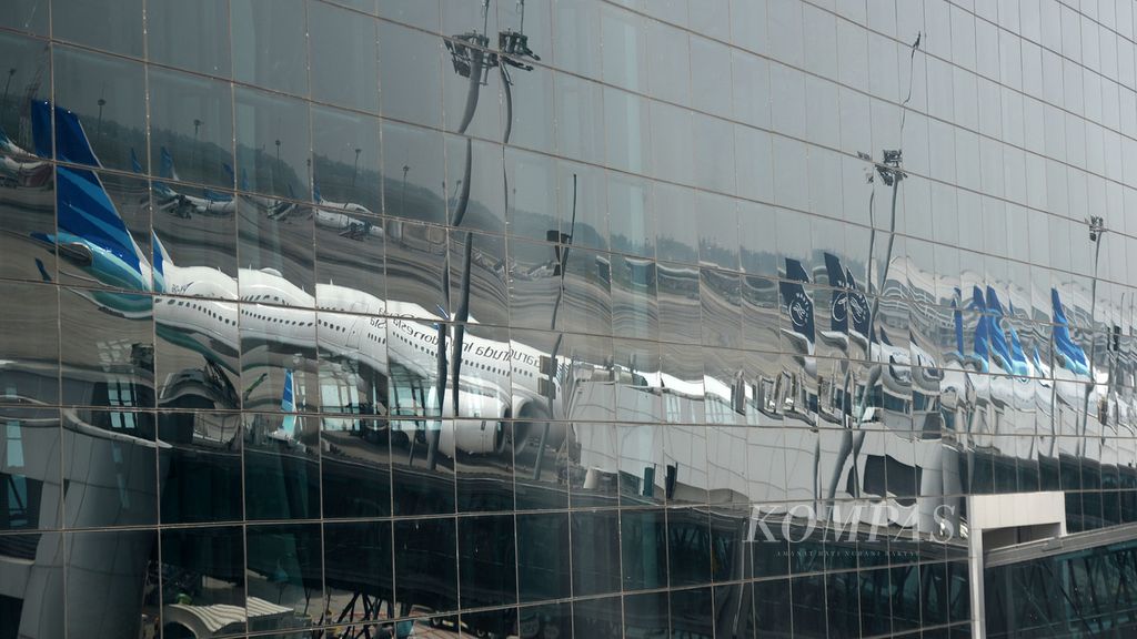 Sejumlah pesawat maskapai Garuda Indonesia terlihat melalui pantulan kaca gedung Terminal 3 di Bandara Internasional Soekarno-Hatta, Tangerang, Banten, Jumat (11/6/2021). Maskapai tersebut terus berupaya beroperasi secara normal meski tengah dililit utang dan terus merugi.