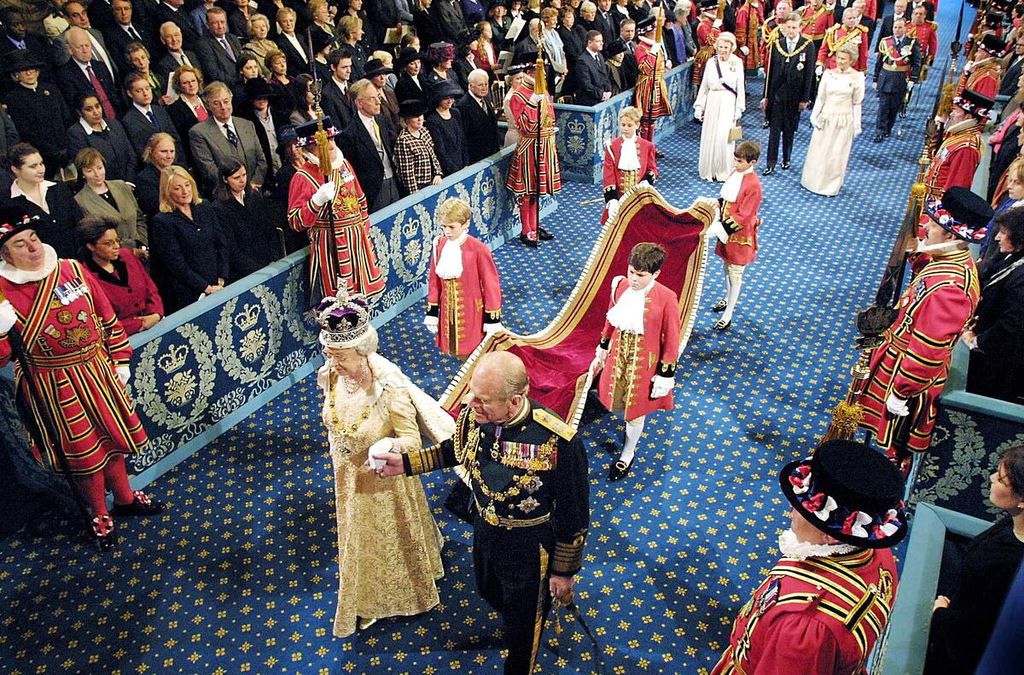 Dalam foto tanggal 13 November 2002 ini, Ratu Elizabeth II (tengah, kiri) mengenakan Mahkota Kerajaan, didampingi suaminya, Pangeran Philip, Duke of Edinburgh, berjalan dalam prosesi melewati The Royal Gallery sebelum menyampaikan pidato dalam pembukaan sidang parlemen di London, Inggris. 