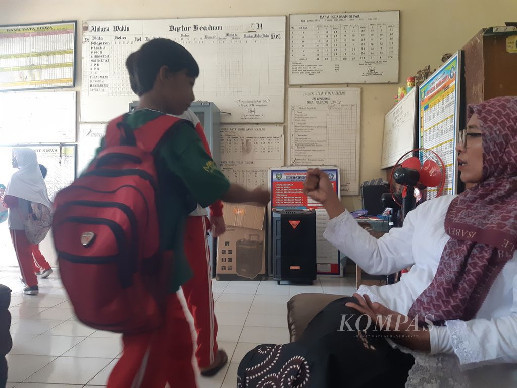 Srihani (41) bersalaman dengan sejumlah siswa di salah satu sekolah dasar negeri di Kecamatan Widasari, Kabupaten Indramayu, Jawa Barat, Selasa (22/11/2022). 