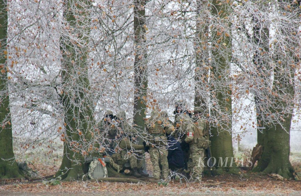 Tentara Ukraina menanti giliran latihan dasar perang darat, Jumat (1/12/2023), di Inggris selatan. Latihan itu bagian dari Operasi Interflex, program Inggris untuk mempersiapkan pasukan infantri Ukraina. Inggris menggandeng 10 negara dalam Operasi Interflex