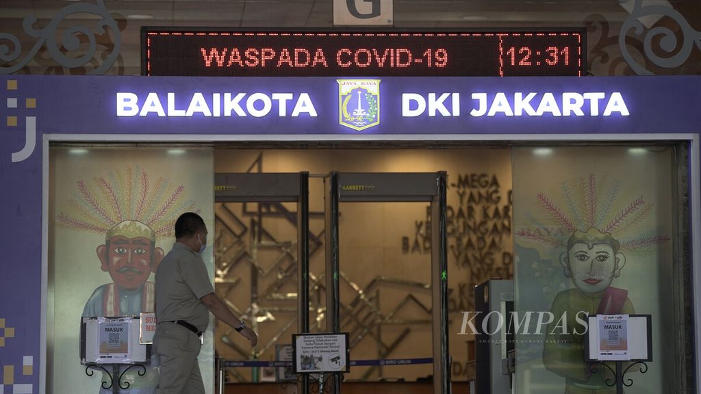 Pegawai memasuki pintu Balai Kota DKI Jakarta di Jalan Medan Merdeka Selatan, Jakarta Pusat, Selasa (1/12/2020).