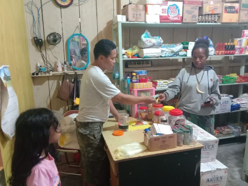 Tampak Marthen Tangalele, salah seorang pedagang di Distrik Elelim, Kabupaten Yalimo, sedang melayani pembeli pada Senin (13/12/2021). Kios Marthen berada di ruas jalan Trans-Papua rute Jayapura-Wamena yang melintasi satu kota dan tiga kabupaten.