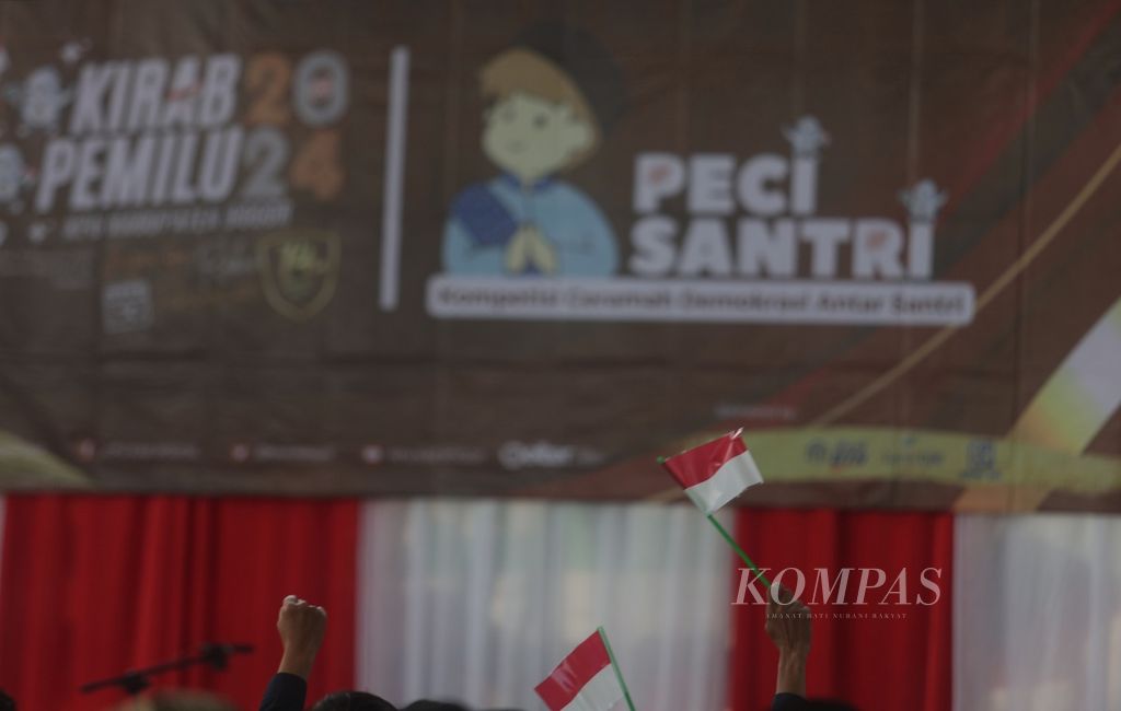 Santri mengibarkan bendera Merah Putih saat kegiatan Peci Santri (kompetisi ceramah demokrasi antarsantri) yang merupakan bagian dari Kirab Pemilu 2014 di Pondok Pesantren Nurul Hikmah, Jonggol, Kabupaten Bogor, Jawa Barat, Jumat (17/11/2023). 