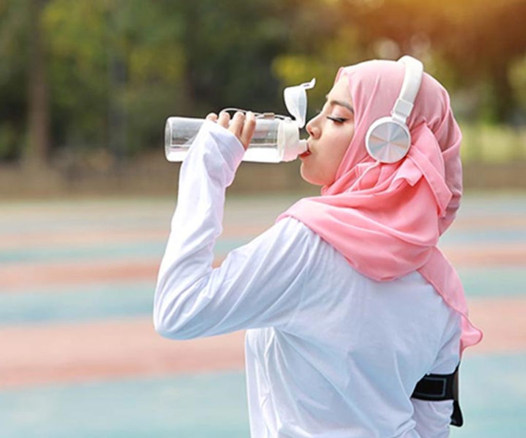 perempuan muslim mengonsumsi air putih 