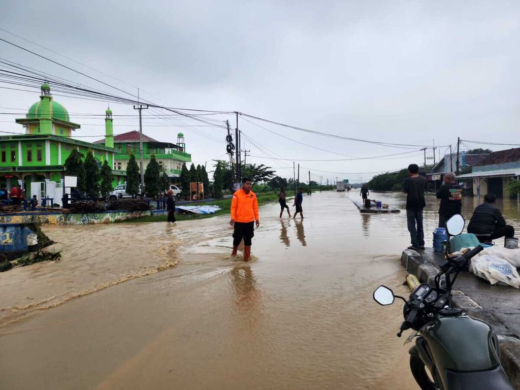 Petugas Badan Penanggulangan Bencana Daerah Kabupaten Majalengka mengecek kondisi banjir di Kecamatan Kertajati, Kabupaten Majalengka, Jawa Barat, Senin (12/2/2024). Banjir itu merendam 1.300 rumah, termasuk pintu keluar Tol Kertajati.