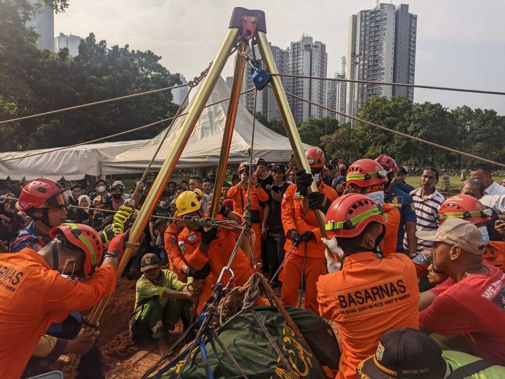 Petugas dari Basarnas dan Sudin Damkar Jakarta Pusat menggunakan <i>hauling system</i> untuk menguburkan jenazah Fajri di TPU Menteng Pulo, Kamis (22/6/2023).