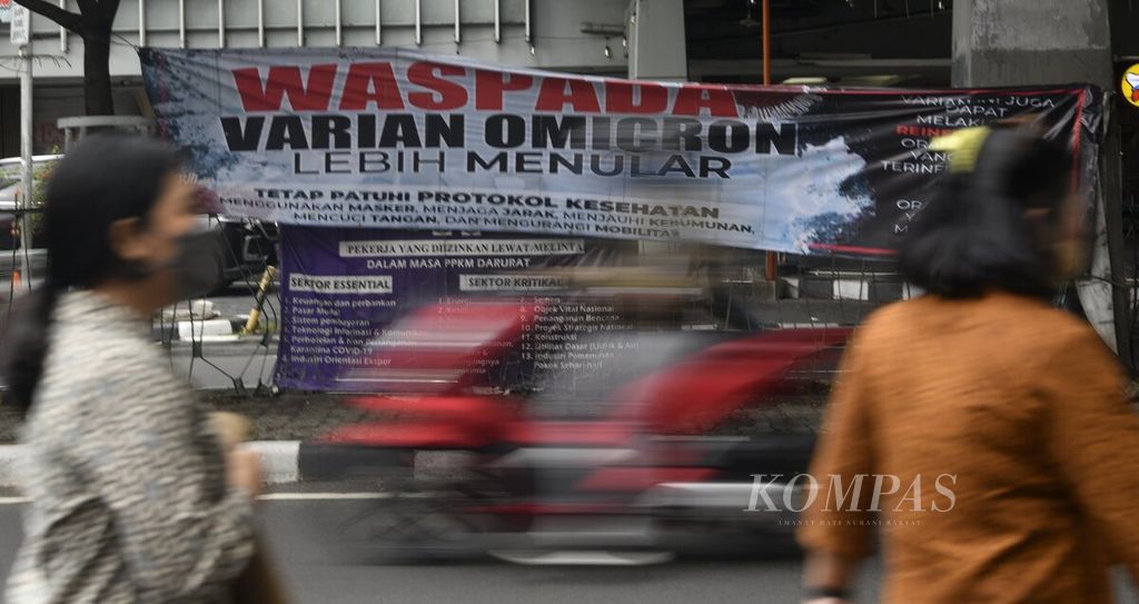 Spanduk dengan pesan untuk mewaspadai penularan Covid-19, terutama varian Omicron, terpasang di Jalan Samanhudi, Jakarta Pusat, Selasa (25/1/2022). 