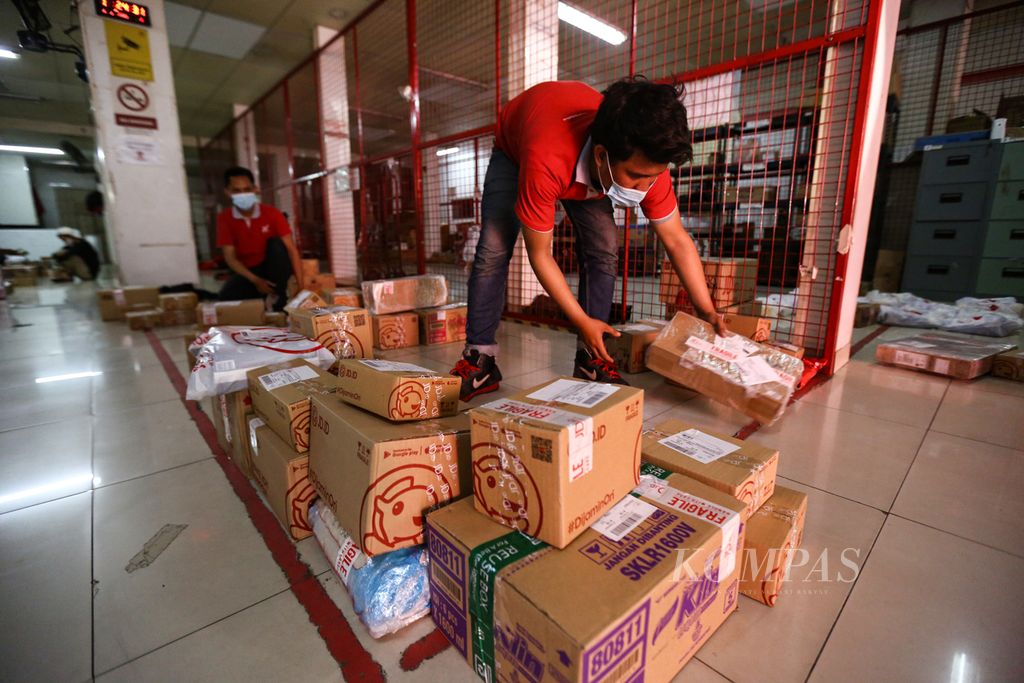 Petugas memilah paket barang berdasarkan lokasi di Drop Point Pancoran JD.ID di Jakarta Selatan, Senin (5/10/2020).