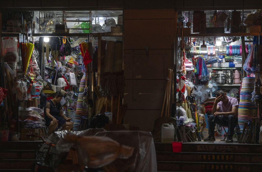 Pedagang toko kelontong yang membuka toko di kawasan permukiman di Beijing, tampak tengah menunggu pembeli pada Kamis (27/7/2023).