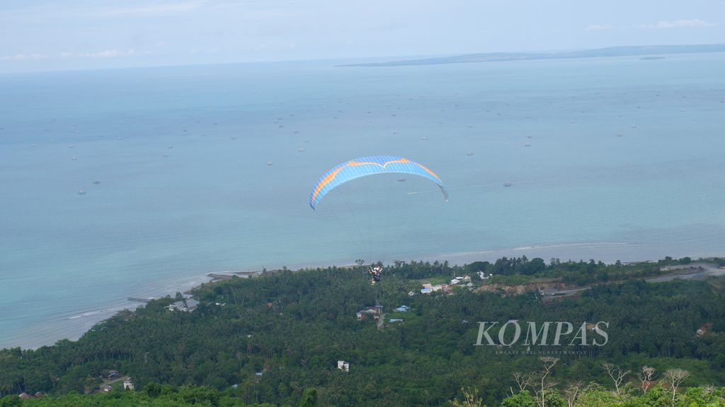 Terbang tandem paralayang dari puncak Bukit Bapake melintasi Desa Sarang Tiung, Kecamatan Pulau Laut Sigam, Kabupaten Kotabaru, Kalimantan Selatan, Kamis (7/7/2022). 