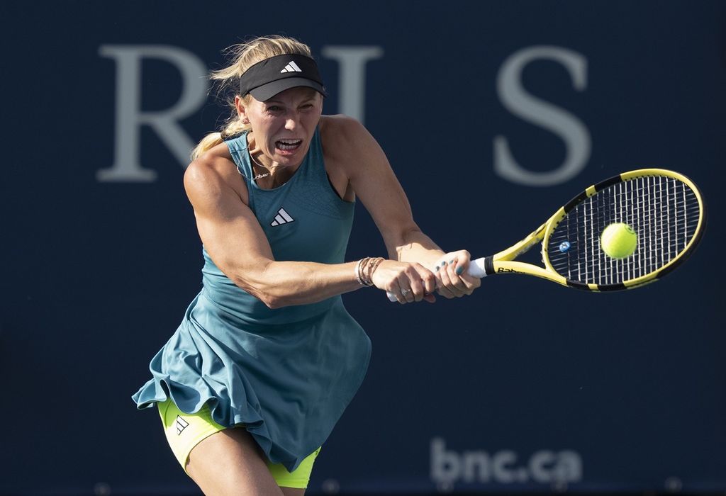 Petenis Denmark Caroline Wozniacki mengembalikan bola ke petenis Ceko Marketa Vondrousova pada WTA Montreal, Rabu (9/8/2023) di Montreal, Kanada. Wozniacki kalah dengan skor 2-6, 5-7.
