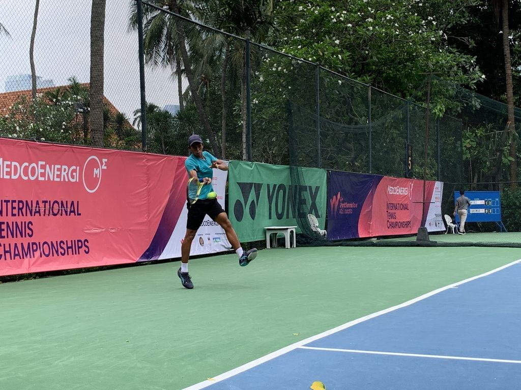 Petenis yunior Indonesia, Claudio Renardi Lumanauw, berupaya mengembalikan bola pukulan  petenis Australia, Matthew Woerndle, pada babak 32 besar seri kedua turnamen tenis internasional Medco Energi 2022 di lapangan tenis Hotel Sultan, Jakarta, Rabu (2/11/2022). Claudio takluk, 3-6, 5-7.