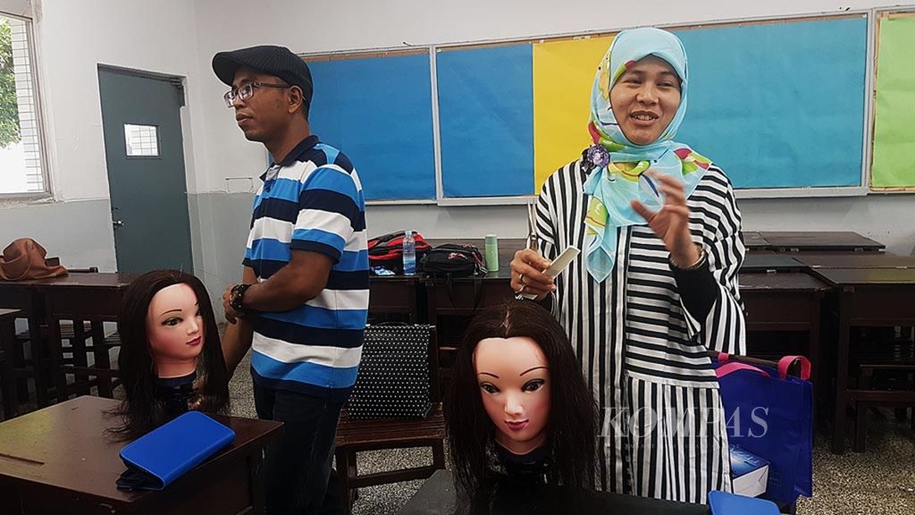 Sri Purwati, an Indonesian migrant worker, is practicing hair styling at a competency improvement program for Indonesian migrant workers in Taipei, Taiwan