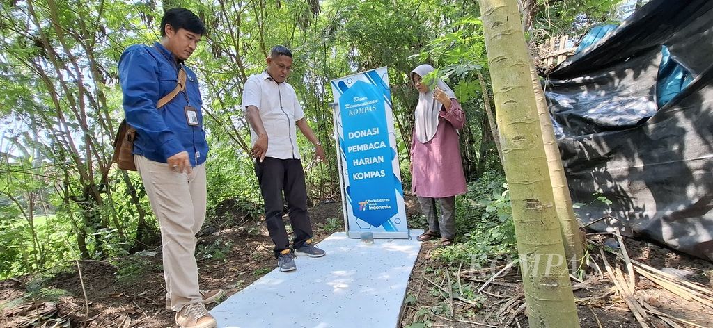 Ketua Yayasan Dana Kemanusiaan Kompas (YDKK) Gesit Ariyanto bersama Ketua Kelompok Swadaya Masyarakat (KSM) Putra Pakuaji Siswoyo melihat <i>septic tank </i>di belakang rumah Nursilah di Kecamatan Pakuhaji, Kabupaten Tangerang, Banten, Rabu (19/6/2024). YDKK menyalurkan dana pembaca harian <i>Kompas</i>/Kompas.id untuk memenuhi kebutuhan sanitasi warga serta mengurangi pencemaran sungai.