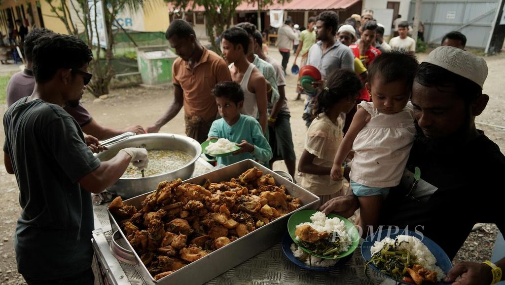 Pengungsi Rohingya mengantre pembagian makan siang di tempat penampungan di Yayasan Mina Raya, Kecamatan Padang Tiji, Kabupaten Pidie, Aceh, Kamis (23/11/2023). 