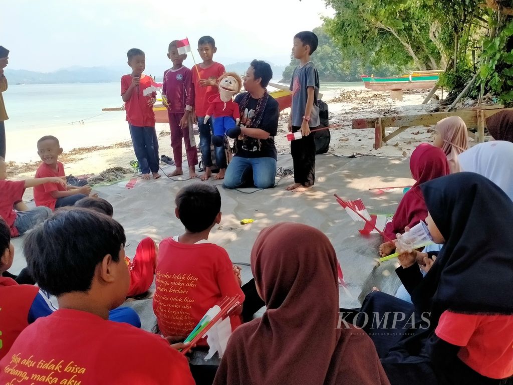 Anak-anak mengikuti kegiatan mendongeng bersama pada acara peringatan Hari Anak Nasional yang digelar sejumlah komunitas di Pulau Tegal, Kabupaten Pesawaran, Lampung, Minggu (23/7/2023). 