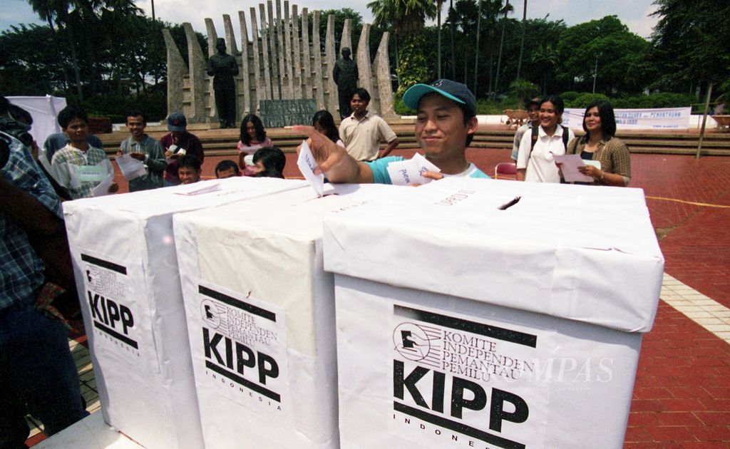 Komite Independen Pemantau Pemilu (KIPP) di depan patung proklamasi, Jakarta Pusat, mengadakan simulasi Pemilu 1999, Minggu (16/5/1999). Simulasi dilakukan dengan penusukan tanda gambar di dalam bilik tertutup dan juga proses memasukkan kartu pilihan ke dalam kotak suara. 