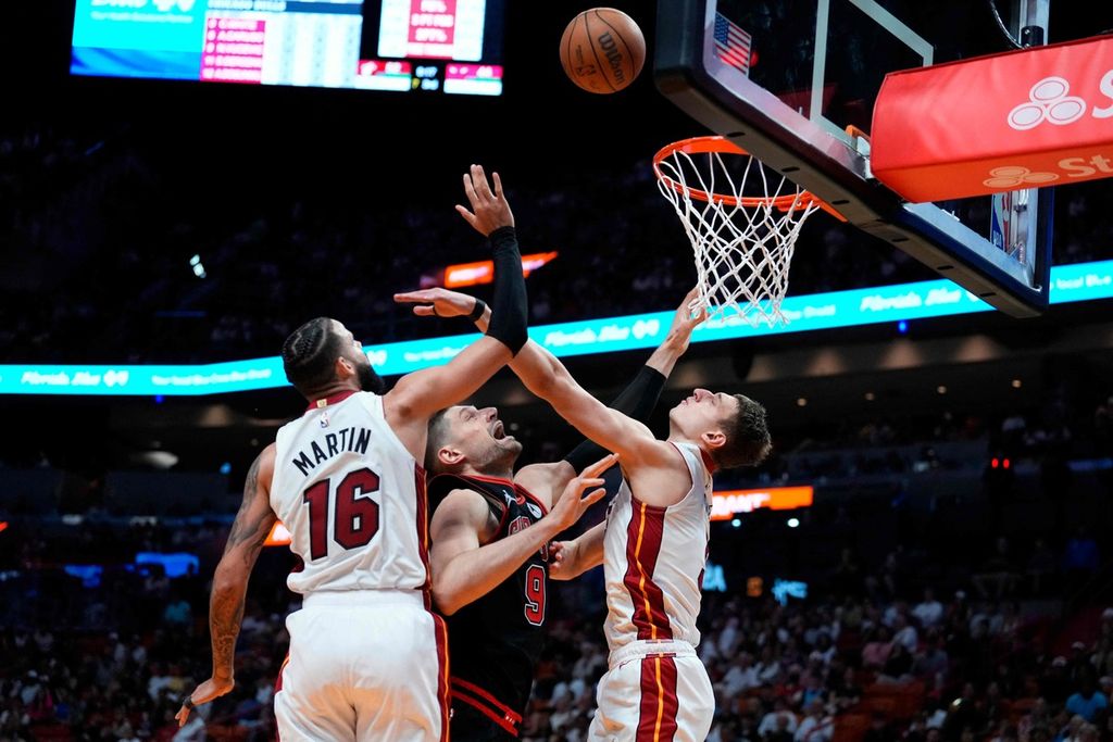 Pebasket Miami Heat, Caleb Martin, melakukan pelanggaran terhadap pebasket Chicago Bulls, Nikola Vucevic, dalam pertandingan babak <i>play-in</i> NBA di Kaseya Center, Miami, Florida, Sabtu (20/4/2024) WIB.