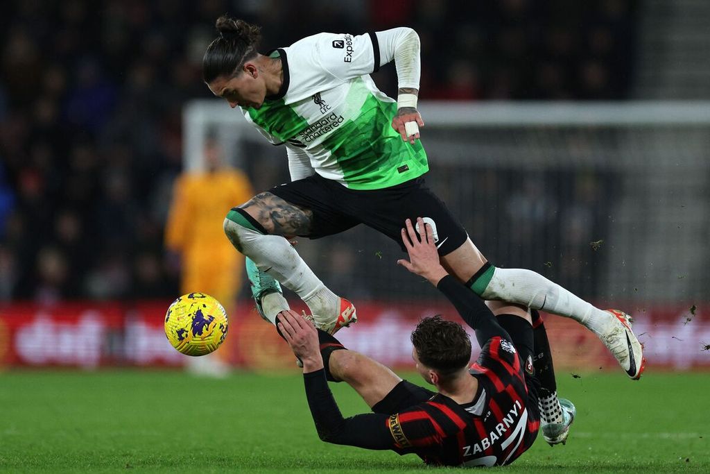 Striker Liverpool Darwin Nunez (atas) berduel dengan bek Bournemouth Illia Zabarnyi saat laga Liga Inggris di Stadion Vitality, Bournemouth, Senin (22/1/2024) dini hari WIB. Nunez mencetak dua gol pada laga yang dimenangi Liverpool dengan 4-0.