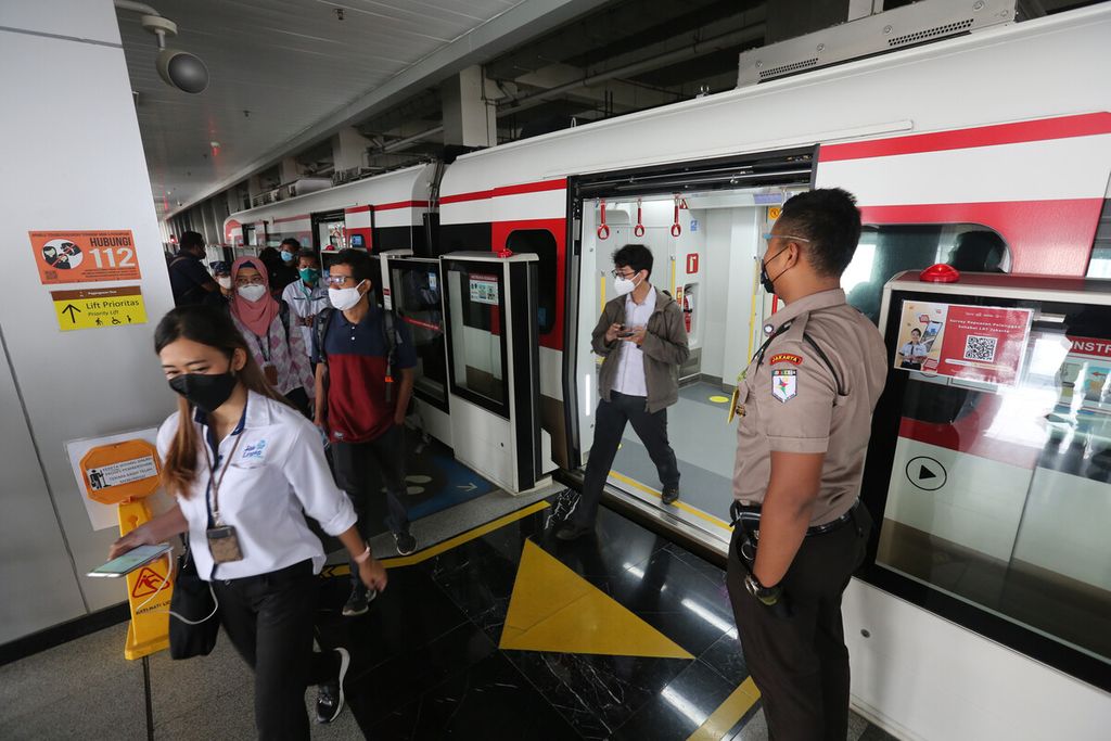 Rombongan jurnalis berjalan keluar dari kereta LRT saat ujicoba penggunaan kartu JakLingko untuk empat jenis moda transportasi publik di Jakarta, Senin (4/10/2021). 