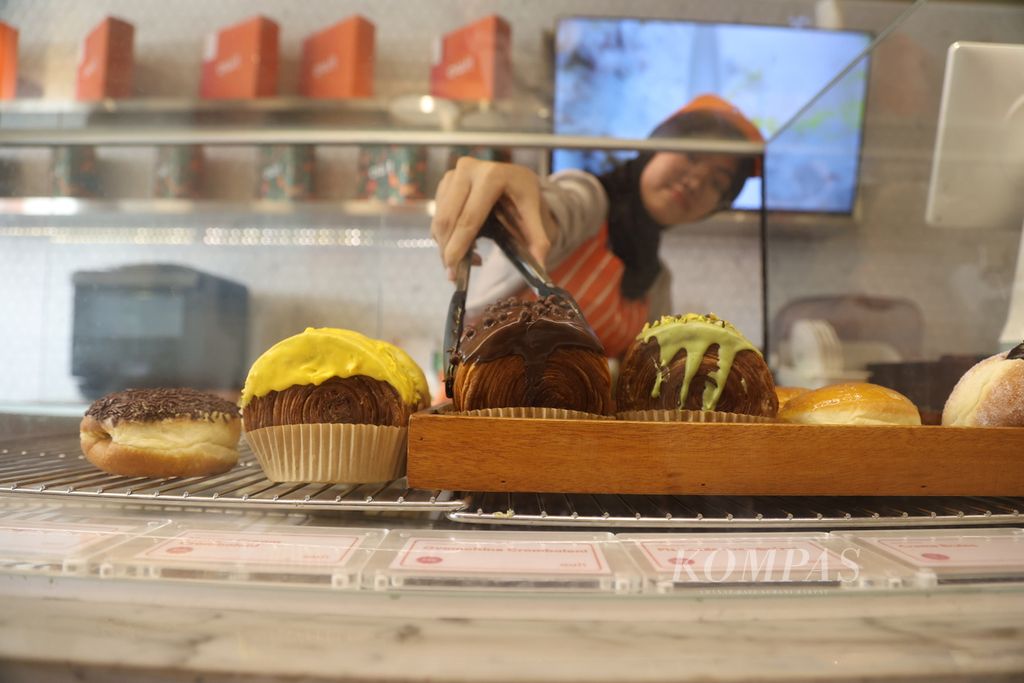 Pekerja mengambil cromboloni untuk pembeli di OUI! Croissant Bar, Pantai Indah Kapuk, Jakarta Utara, Selasa (12/12/2023).