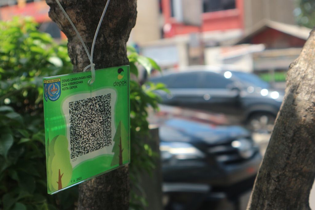 Salah satu kode batang (<i>barcode</i>) yang dipasang di pohon yang berada di tengah pembatas Jalan Margonda Raya, Selasa (29/11/2022). Sebanyak 1.500 pohon di sekitar Jalan Margonda Raya dan Jalan Juanda dipasangi kode batang oleh Pemerintah Kota Depok.