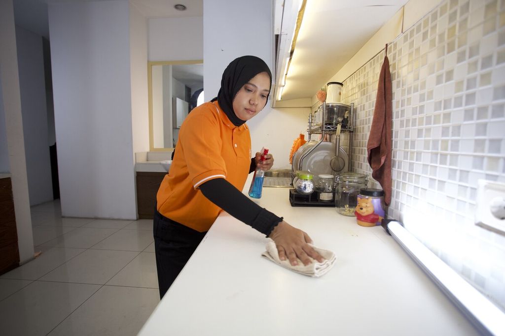 Seorang tasker yang bekerja untuk bTaskee Indonesia terlihat sedang membersihkan dapur di Jakarta Selatan, Desember 2023. Layanan jasa pembersih merebak di berbagai kota di Asia oleh karena kecenderungan generasi muda yang tidak menginginkan kehadiran orang asing termasuk asisten rumah tangga secara menetap di sebuah hunian.