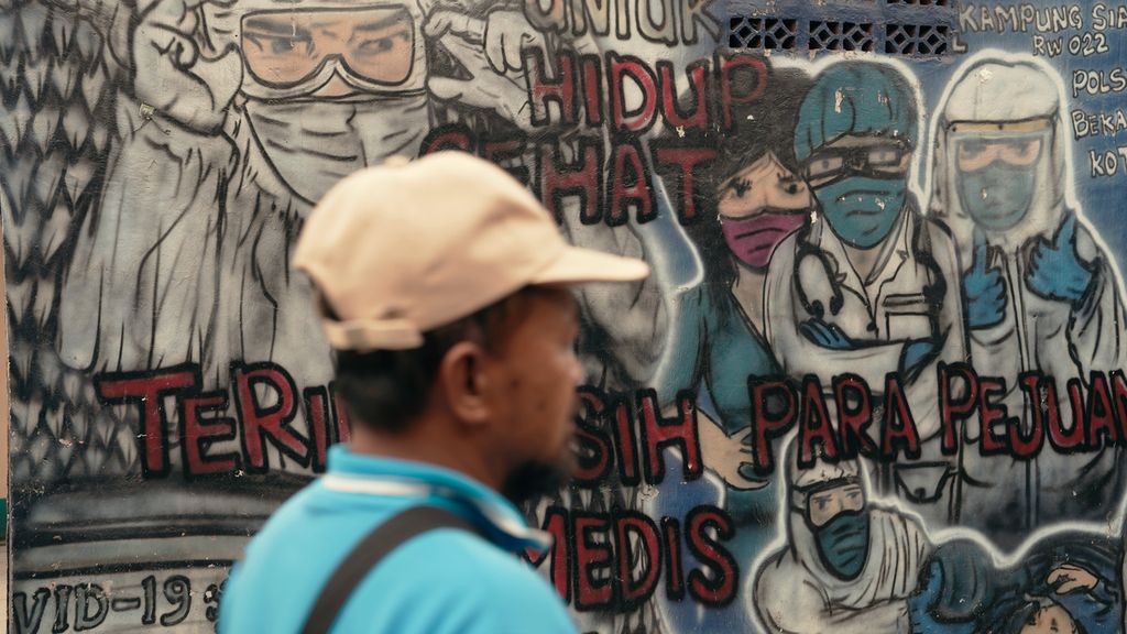 Warga melintasi mural ucapan terima kasih kepada tenaga kesehatan di Kota Bekasi, Jawa Barat, Kamis (1/9/2022). Secara hitungan kasar sesuai standar WHO, yaitu satu dokter untuk 1.000 penduduk, Indonesia masih berada di urutan terbawah di Asia Tenggara menurut laporan WHO tahun 2018.