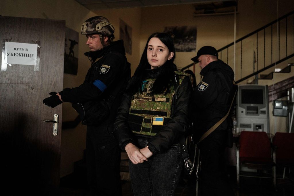 Seorang perempuan menanti dievakuasi bersama orangtuanya di sebuah kantor pemerintahan sipil setempat di kota Kozacha Lopan, yang baru direbut kembali oleh pasukan Ukraina, wilayah Kharkiv, Ukraina, Selasa (20/9/2022). 