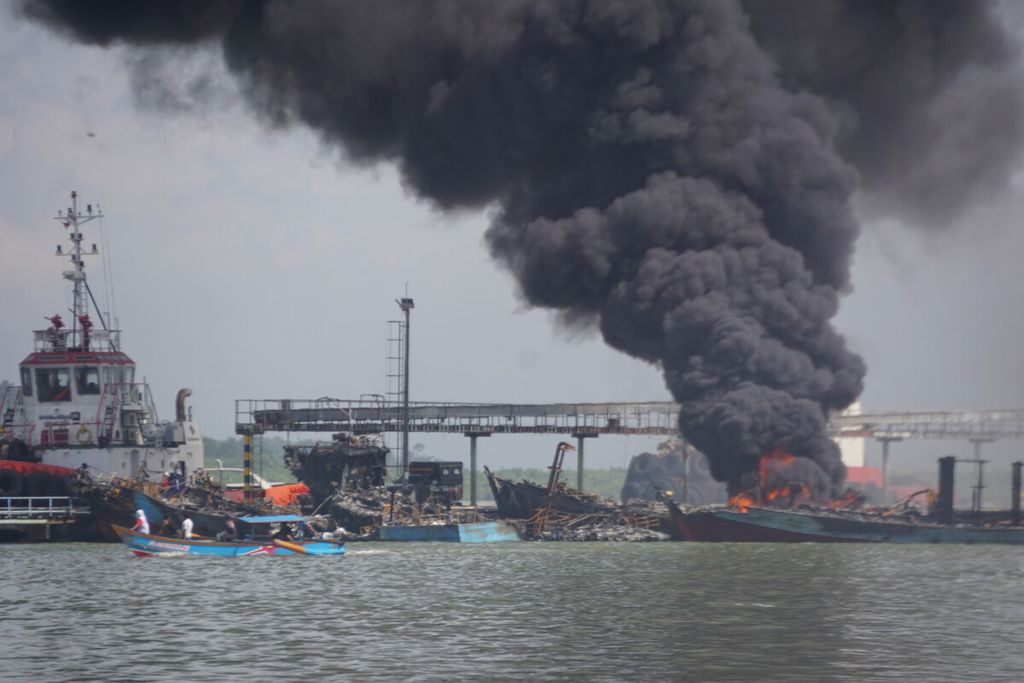 Sebuah kapal masih terbakar dan tampak pula puing-puing kapal terbakar yang teronggok di sekitar Dermaga Wijayapura, Cilacap, Jawa Tengah, Rabu (4/5/2022) pagi. Total ada 45 kapal yang terbakar sejak Selasa sore dan kerugian material mencapai Rp 130 miliar.