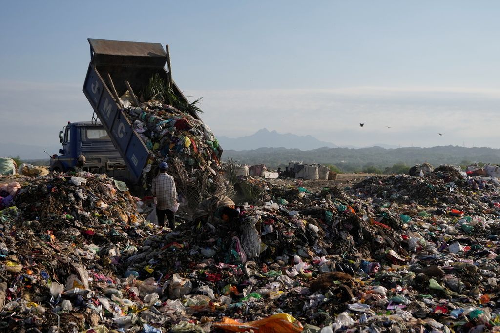 Truk sampah membongkar muatan berupa plastik dan sampah lainnya di pinggiran Jammu, India, Senin (22/4/2024). 