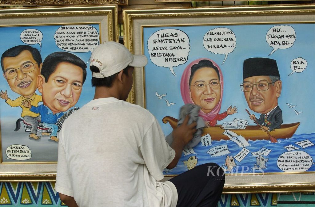 A worker was seen cleaning a painting depicting two presidential and vice-presidential candidates who were leading the vote count in the Pasar Baru area of ​​Central Jakarta on Wednesday, July 7, 2004. The pair of Megawati Soekarnoputri - Hasyim Muzadi and the pair of Susilo Bambang Yudhoyono - Jusuf Kalla were confirmed to advance to the second round of the 2004 presidential election.