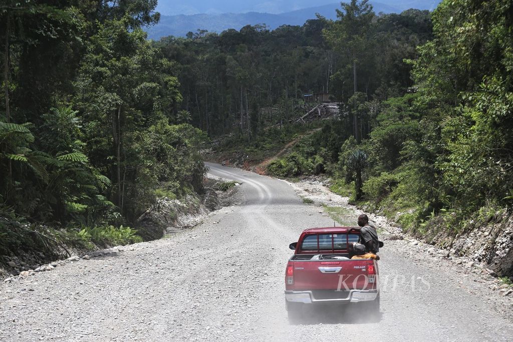 Kendaraan melintas di Jalan Trans-Papua seksi Nduga-Mumugu, Sabtu (16/10/2021). Jalan trans sepanjang 40 kilometer sebagian besar berupa jalan batu yang diperkeras dan masih dengan mudah ditemui lubang menganga.