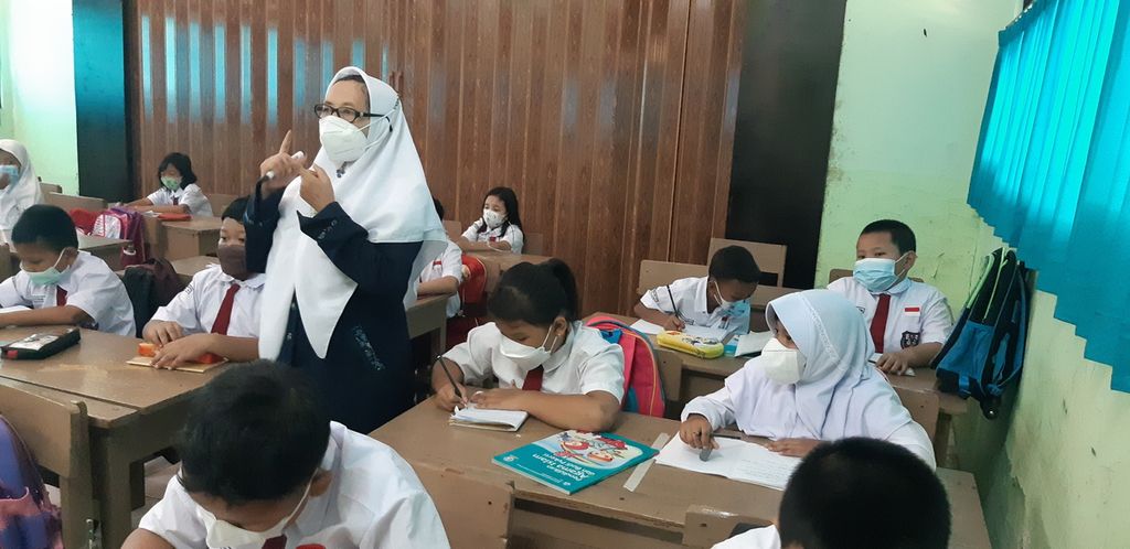 Guru Pendidikan Agama Islam menjelaskan pelajaran ke murid kelas II SDN 16 Kramatjati, Jakarta Timur, Senin (3/1/2022).