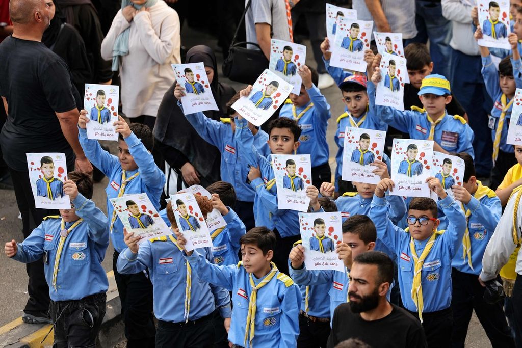 Anak-anak pramuka Lebanon membawa foto teman mereka yang tewas dalam serangan teror ledakan penyeranta, Selasa (17/9/2024), di Lebanon. Banyak anak-anak yang tewas dan terluka dalam serangan teror ledakan perangkat elektronik yang terjadi dua kali, yakni pada 17-18 September 2024, itu  di Lebanon selatan dan kota Beirut.