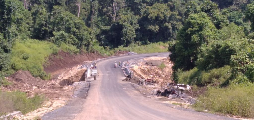 Beberapa pekerja menyelesaikan bagian dari Jalan Lintas Selatan di Kabupaten Malang, Jawa Timur, atau tepatnya di sisi barat Pantai Balekambang di Kecamatan Bantur mengarah ke barat, Rabu (8/12/2021).