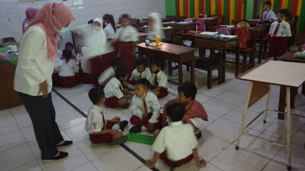 A teacher monitors grade 1 students at SD Negeri Mojo 3, Surabaya, East Java, who are filling their break with traditional games, Wednesday (21/9/2022).