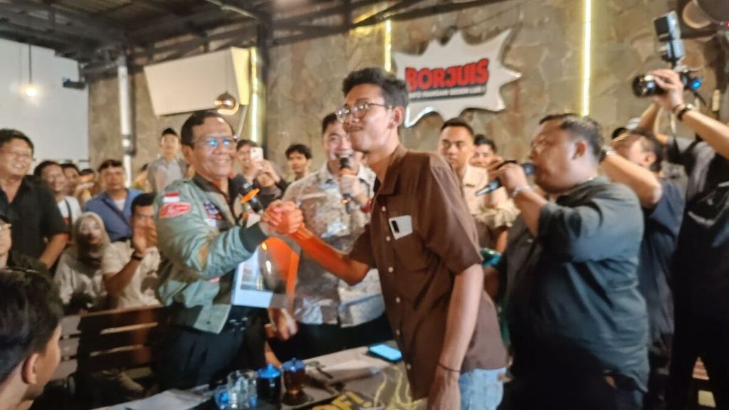 Calon wakil presiden nomor urut 3, Mahfud MD, bersalaman dengan warga dalam acara diskusi Tabrak Prof di sebuah warung kopi di Kota Semarang, Jateng, Selasa (23/1/2024) malam. 