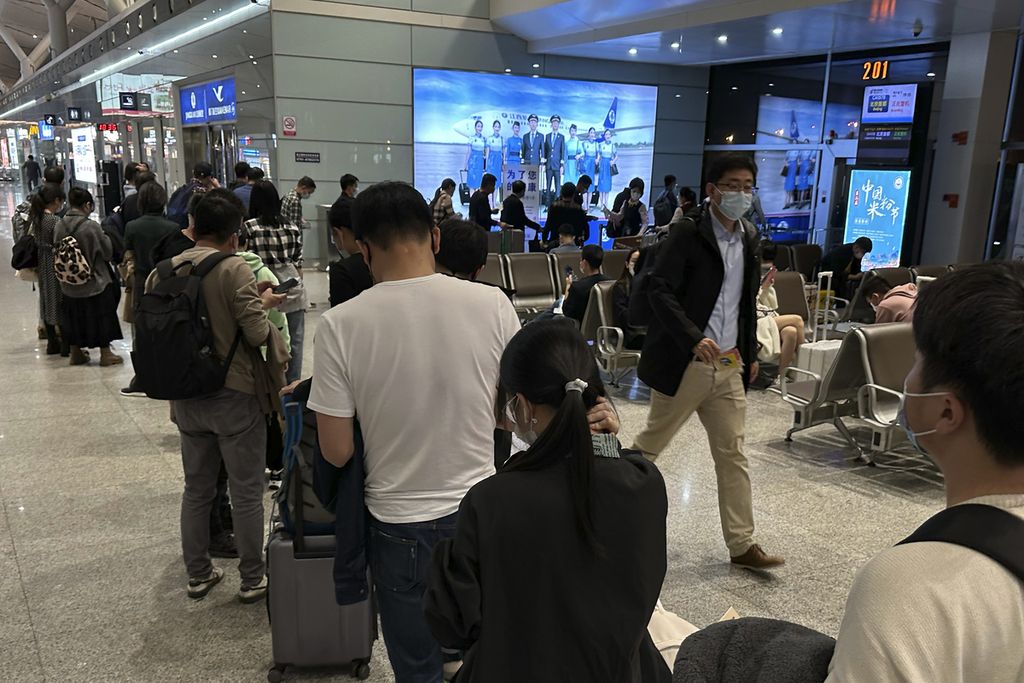 Calon penumpang mengantre masuk ke dalam pesawat di bandara Jiangxi, China, 1 November 2022. Pemerintah China memutuskan untuk membatalkan kewajiban karantina warga dań tamu yang baru datang dari luar negeri.