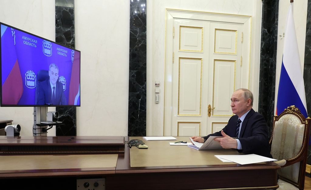 Presiden Rusia Vlamdimir Putin berbincang dengan Gubernur Amur,  Vasily Orlov lewat telekonferensi dari kantornya di Moskwa, Rusia pada 16 Mei 2023. Pada Maret 2023, Mahkamah Kriminal Internasional memerintahkan penangkapan Putin karena memerintahkan serangan ke Ukraina. 