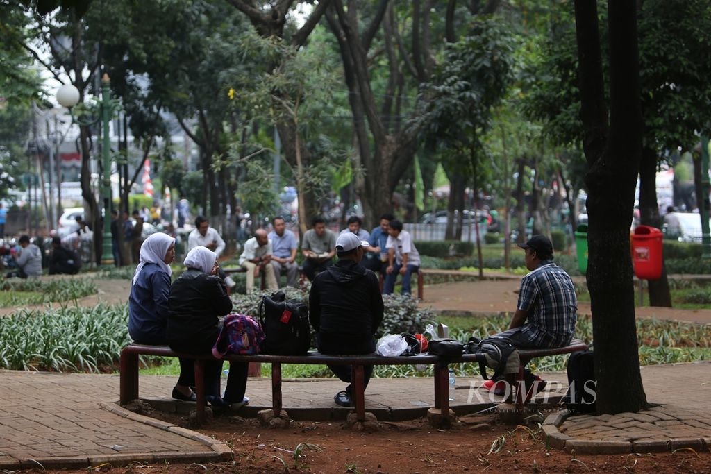 Karyawan bercengkerama saat beristirahat pada jam makan siang di Taman Bakrie, Jalan Rasuna Said, Jakarta Selatan, Selasa (3/9/2019). Taman seluas 2.800 meter persegi yang dikelilingi gedung perkantoran tersebut menjadi jujugan pekerja kantoran saat istirahat siang.