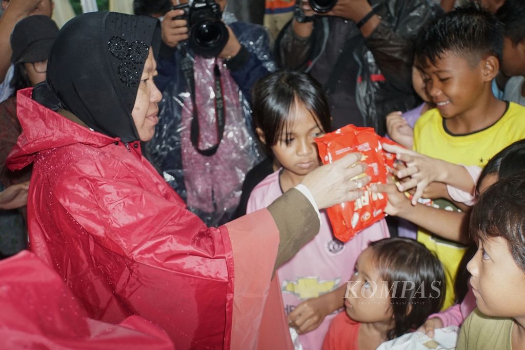 Menteri Sosial Tri Rismaharini memberikan bantuan kepada anak-anak korban banjir, Selasa (31/1/2023), di daerah Molas, Bunaken, Manado, Sulawesi Utara. Banjir dan tanah longsor yang melanda Manado pada Jumat (27/1/2023) menewaskan lima orang dan menyebabkan sedikitnya 1.674 warga mengungsi.