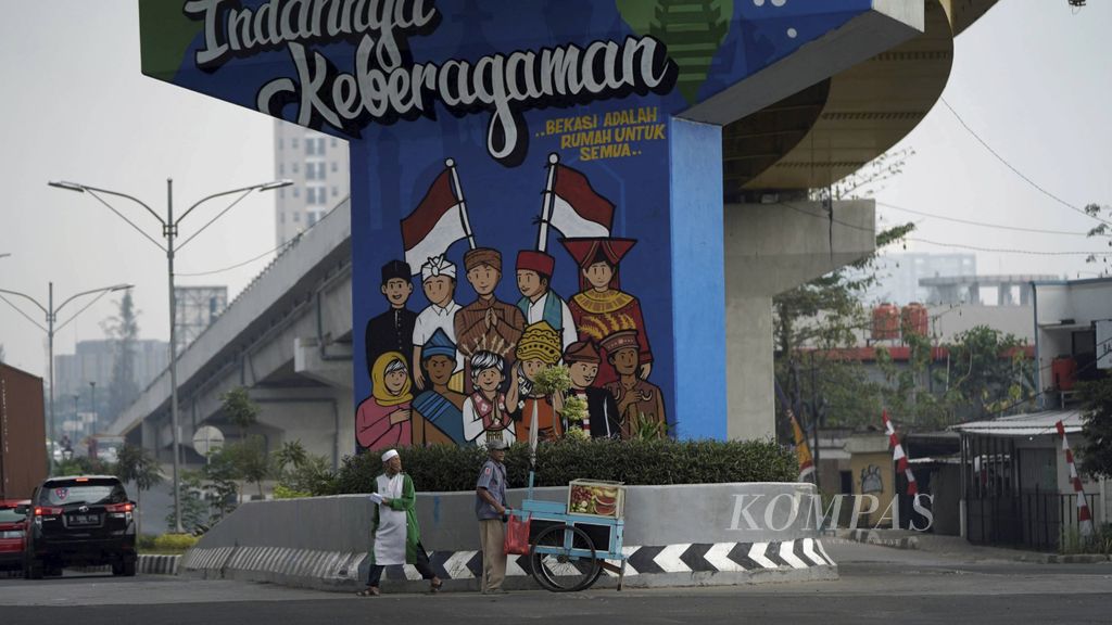 Penjual buah keliling melintas di depan mural keberagaman di kolong jalan layang Rawa Panjang, Kota Bekasi, Jawa Barat, Jumat (7/8/2020). Keberagaman, toleransi dan menghormati perbedaan terus disuarakan untuk menumbuhkan kebersamaan dalam membangun bangsa.