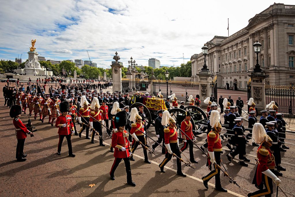 Peti jenazah mendiang Ratu Elizabeth II dibawa dengan kereta pengangkut meriam dalam iring-iringan pasukan Angkatan Laut Inggris dan sedang melewati Istana Buckingham, London, dalam upacara pemakaman, 19 September 2022. 