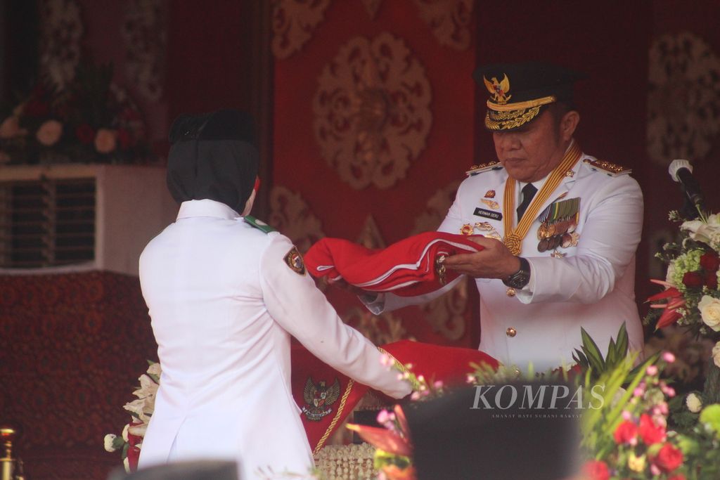 Titah Rahmania membawa bendera pada peringatan Hari Ulang Tahun ke 77 tahun Republik Indonesia di Rumah Dinas Gubernur Sumatera Selatan, Rabu (17/8/2022). Perayaan tahun ini lebih ramai dibanding tahun lalu yang terbatas lantaran pandemi.