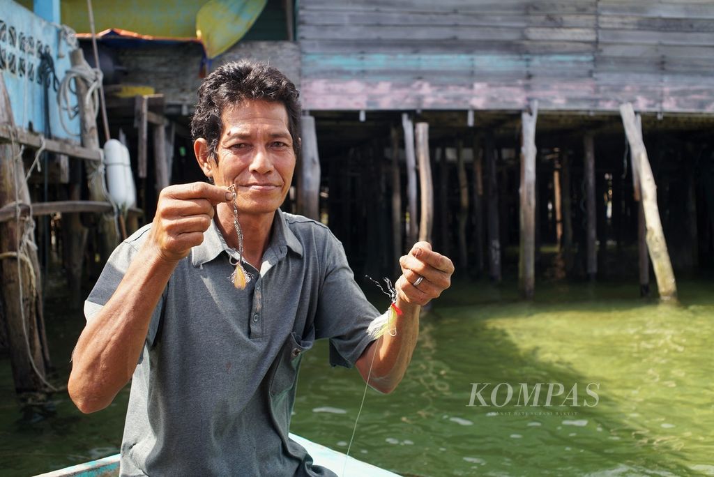 Bujang (65), nelayan di Teluk Baruk, Kecamatan Bunguran Timur, Natuna, Kepulauan Riau, menunjukkan alat pancing yang digunakan untuk menangkap ikan secara tradisional, Kamis (9/1/2020). 