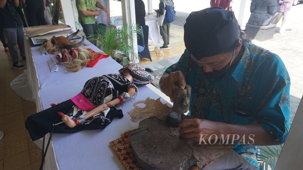 Seorang perajin wayang tengah menatah wayang dalam acara <i>workshop</i> KaTa Kreatif di Kota Surakarta, Jawa Tengah, Sabtu (2/7/2022). Kota tersebut akan diajukan agar menjadi bagian dalam Creative Cities Network dari UNESCO pada 2023.